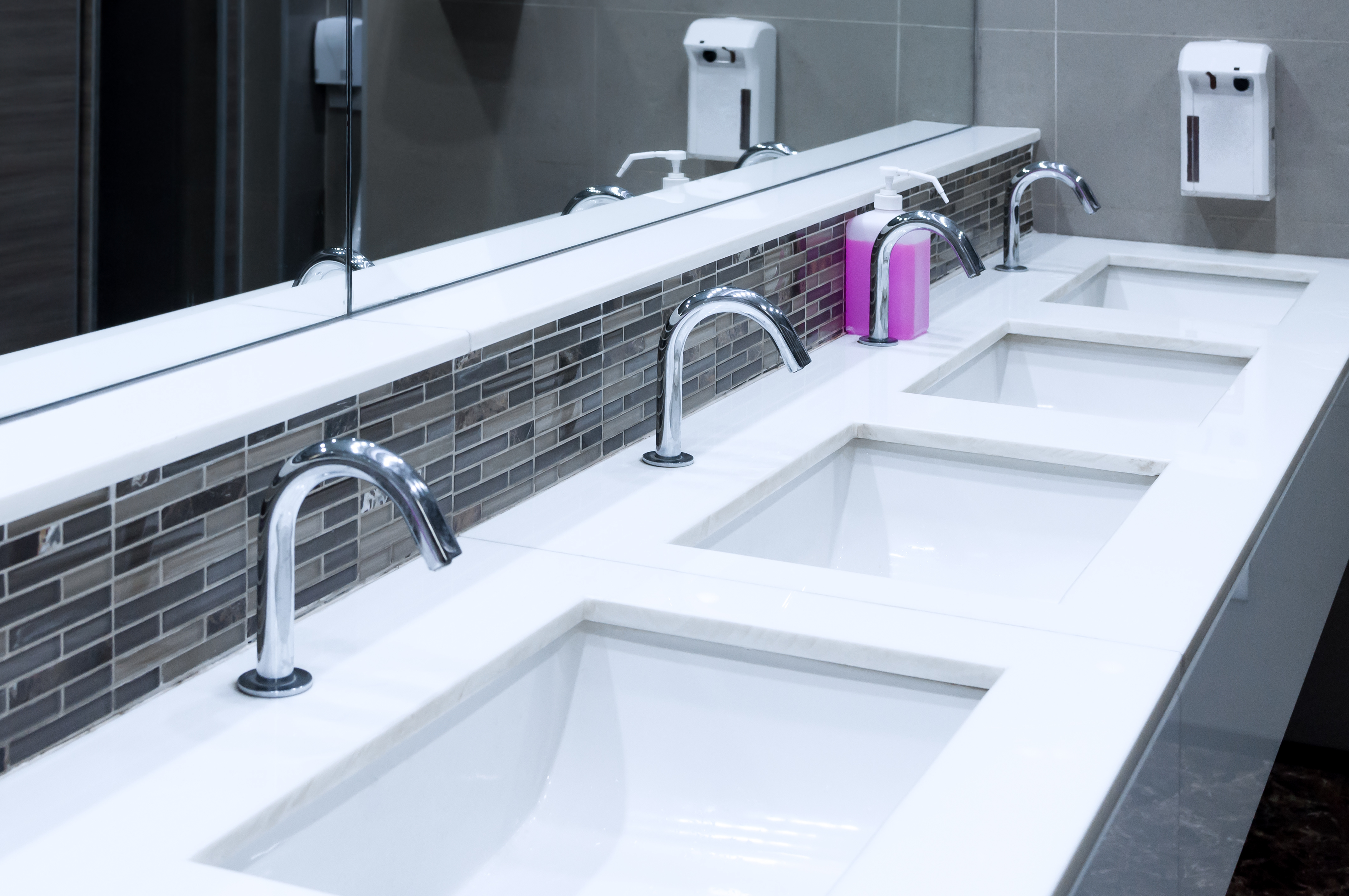A row of sinks in a commercial plumbing project - if you are in need of services, contact WyattWorks today!