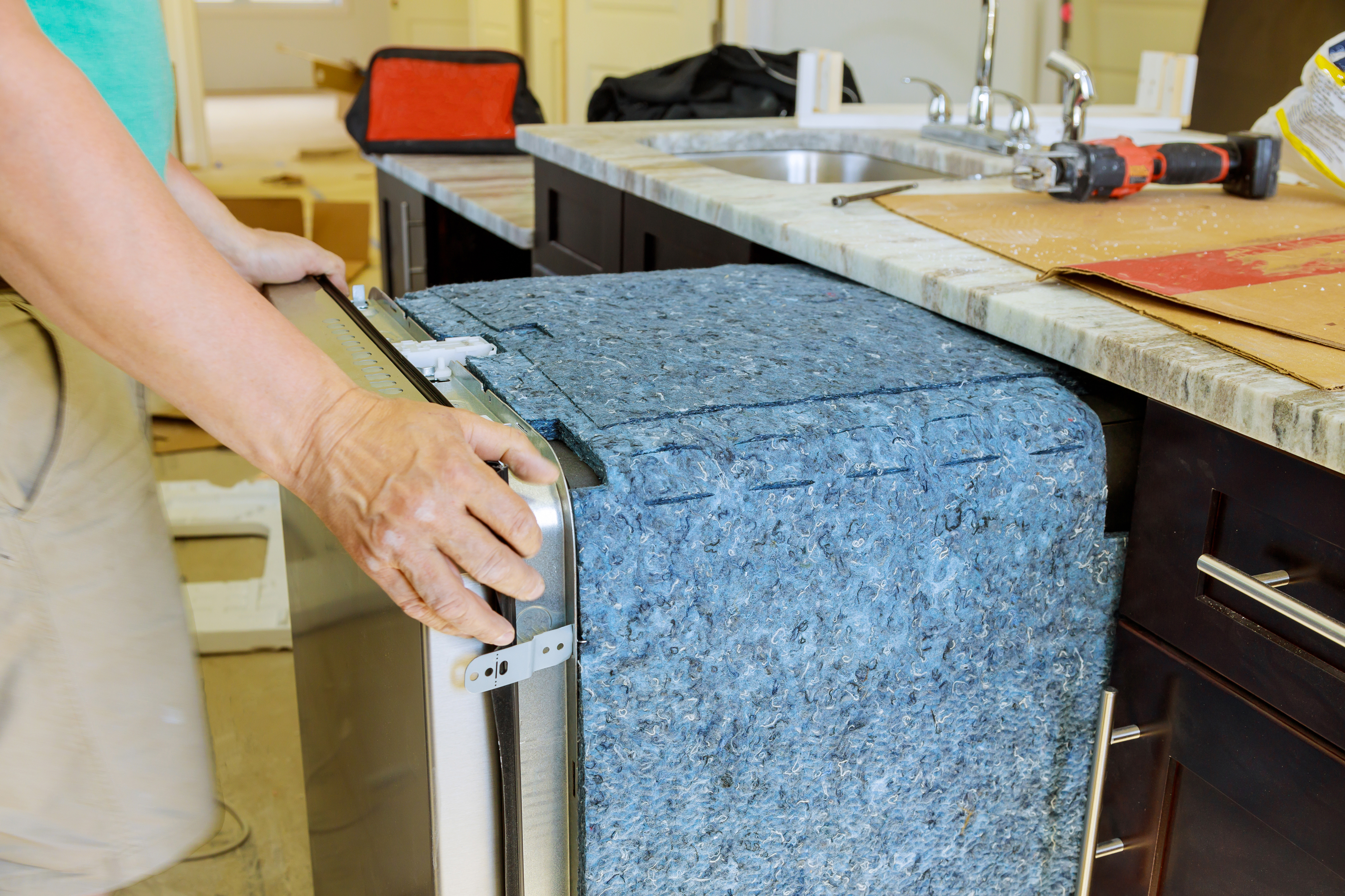 A service provider from WyattWorks working on a dishwasher.