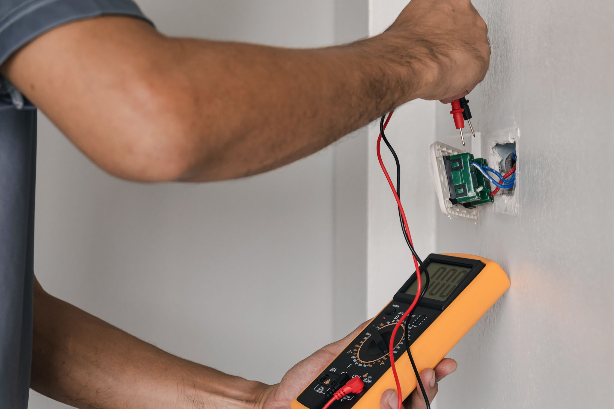 An outlet being inspected by an electrician - WyattWorks offers excellent electrical inspection in Parma / Seven Hills, OH.