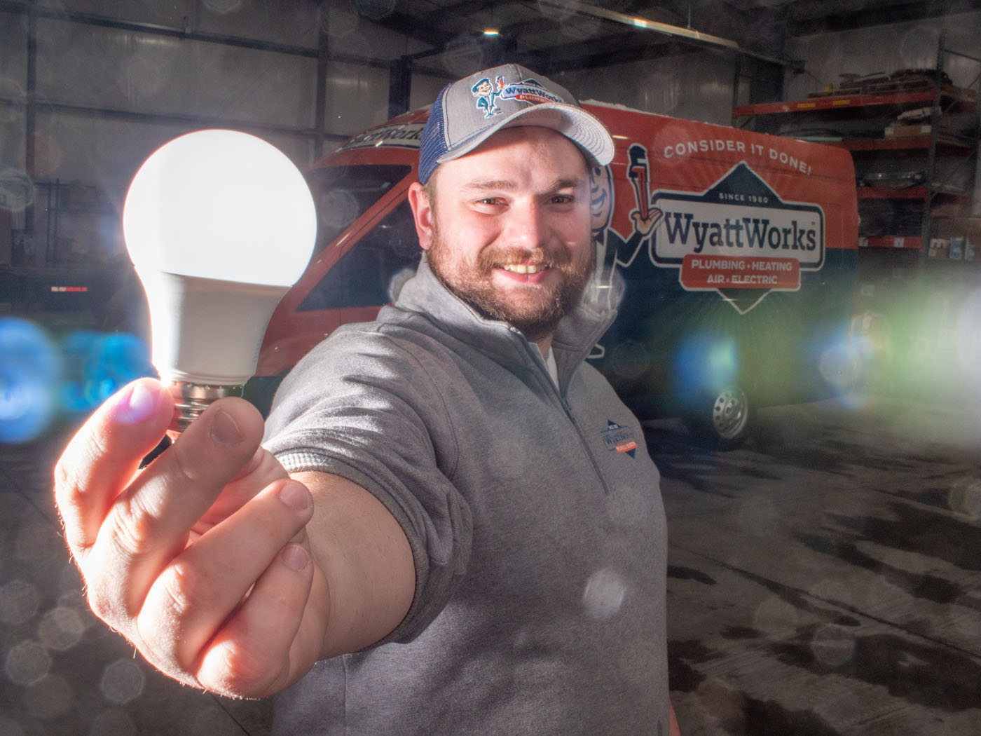 A team member holding a lightbulb - if you're looking for one of the best electricians in Seven Hills, OH, choose WyattWorks.