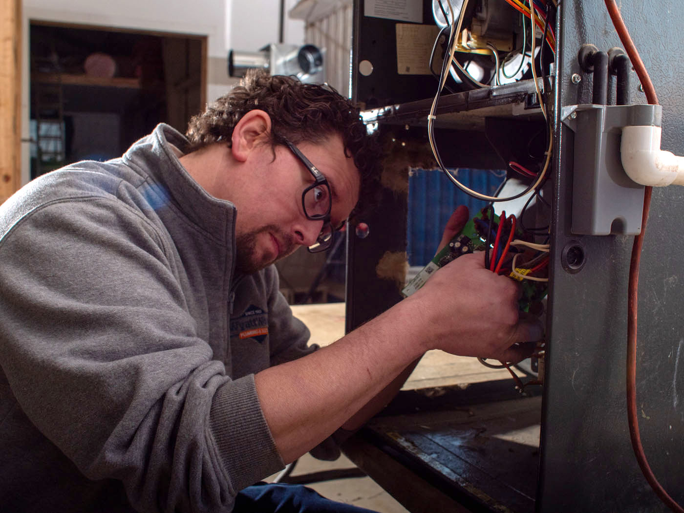 A WyattWorks technician working on an eletrical component for a Ohio & North Carolina air conditioning service repair.