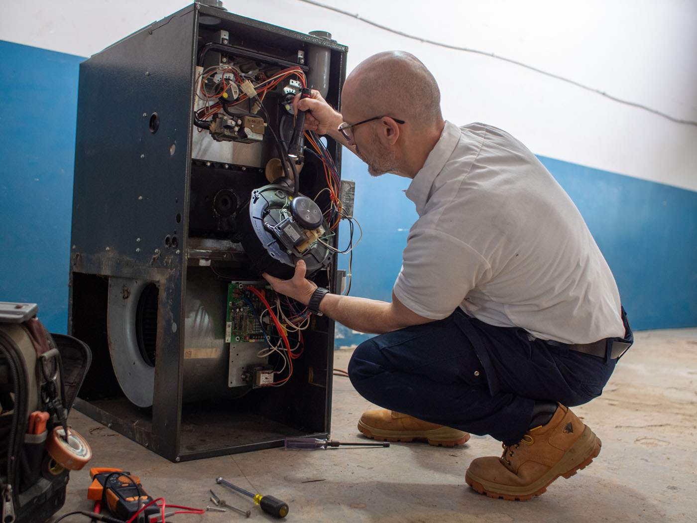 One of WyattWorks heating contractors in Ohio & North Carolina posing in front of a furnace system.