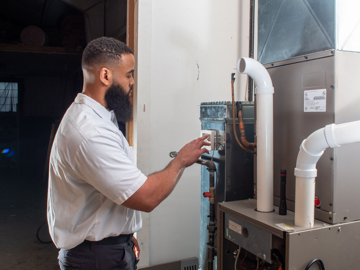 A WyattWorks professional servicing a furnace in Ohio & North Carolina.