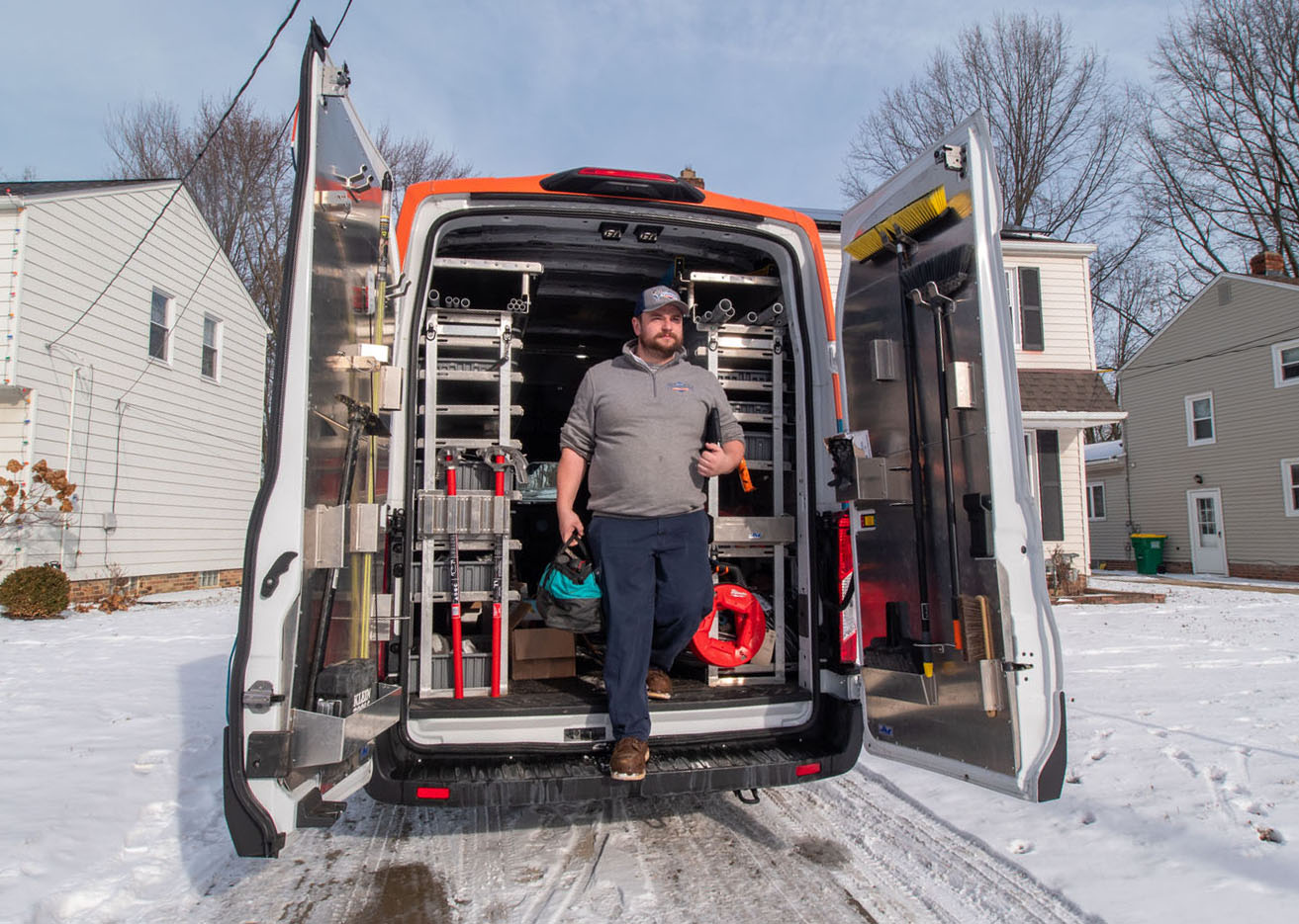 An image of a WyattWorks Plumbing employee unloading equipment from a brand van - WyattWorks is a trusted provider as a drain company in Ohio & North Carolina.